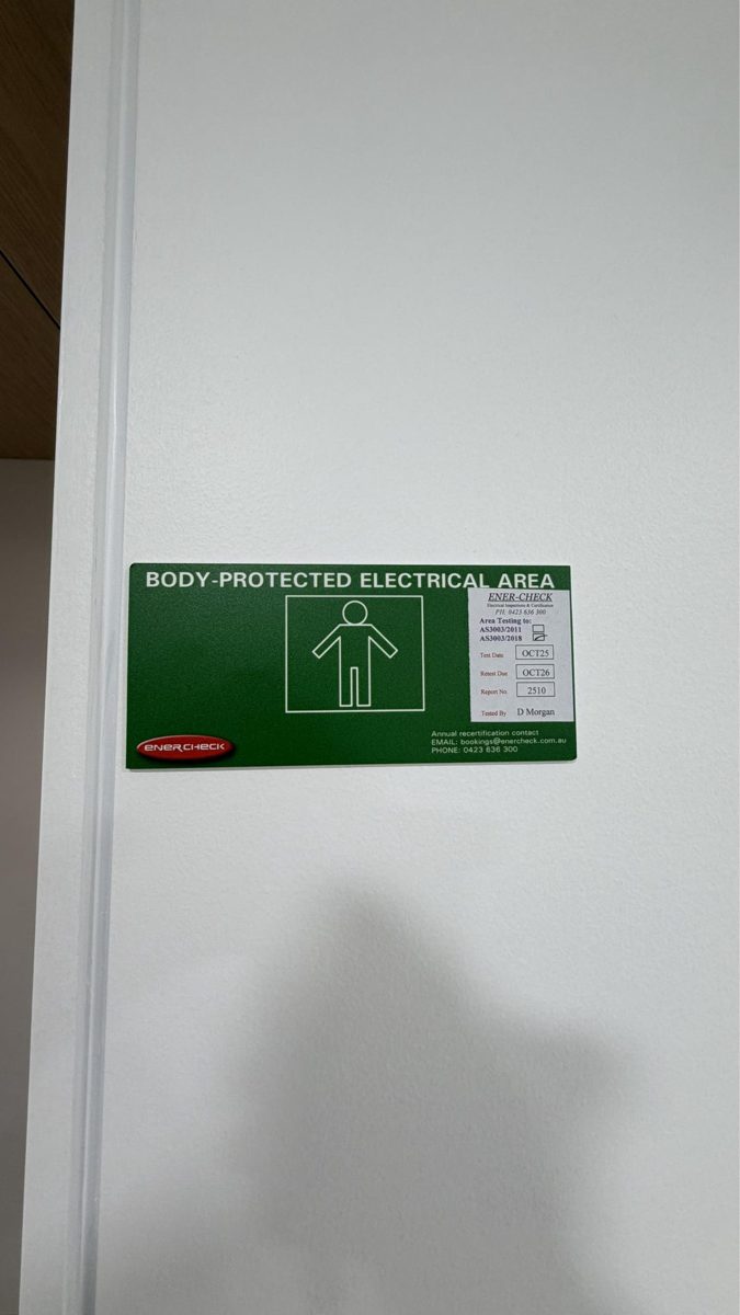 Green body-protected area sign at a treatment room door with a test label